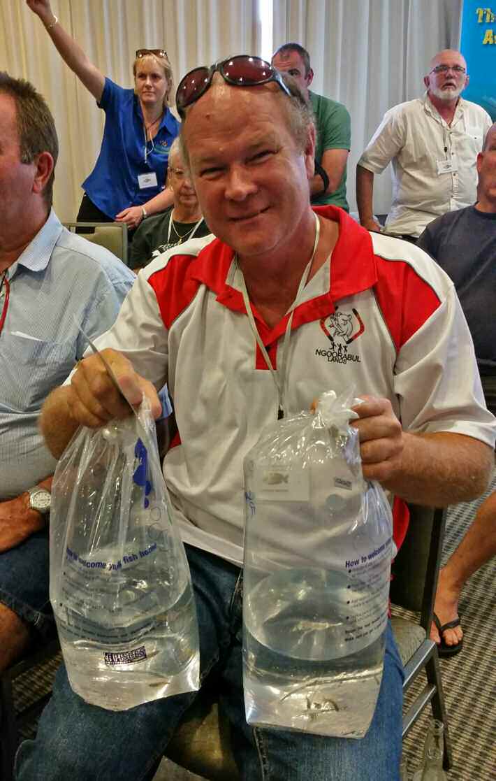 Steve Brooks holding bags of blue-eyes bought at the auction